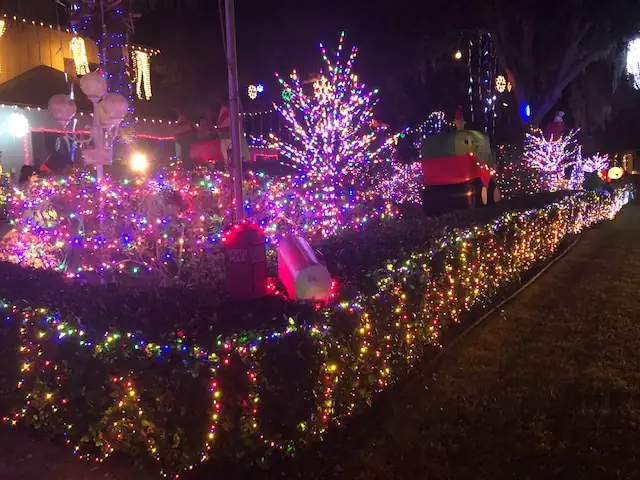 Island homes and trees covered in colorful Christmas lights