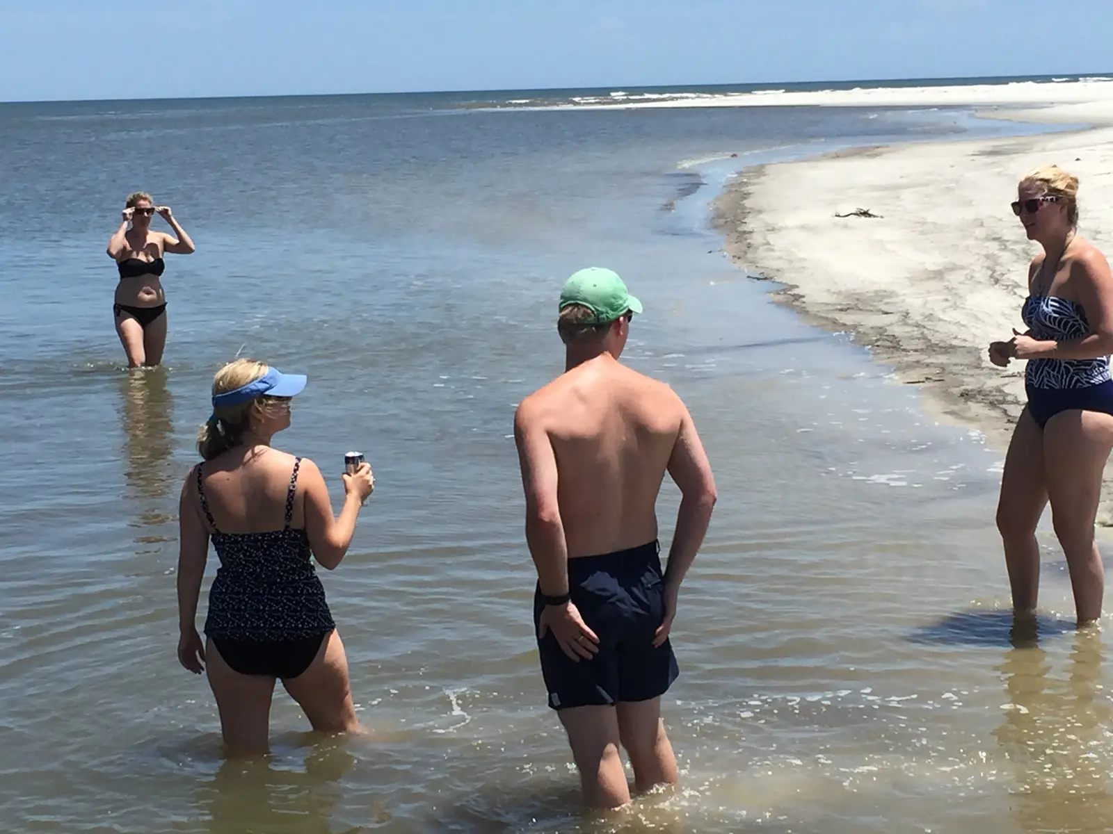 Guests wading at a remote beach on a private shelling trip