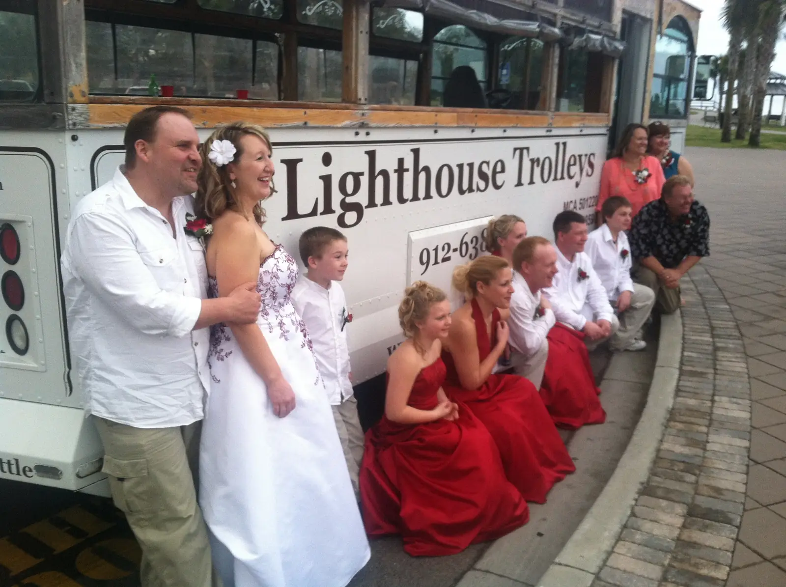 A wedding party gathered beside a Lighthouse Trolleys trolley